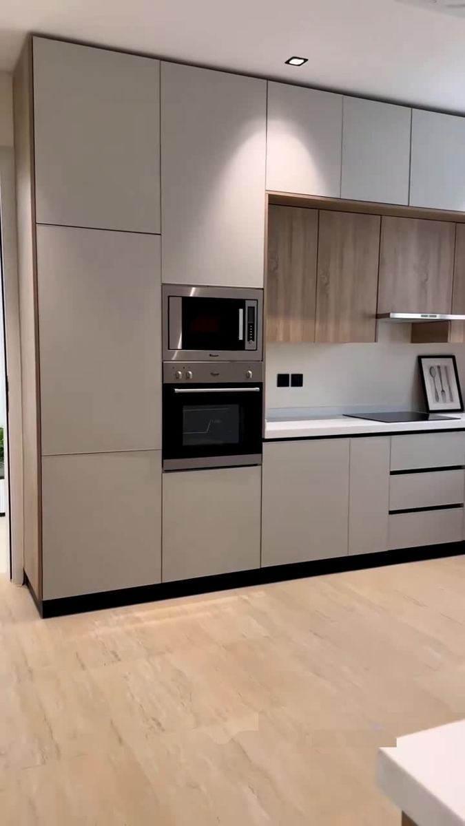 Cocina con columnas de horno y armarios altos